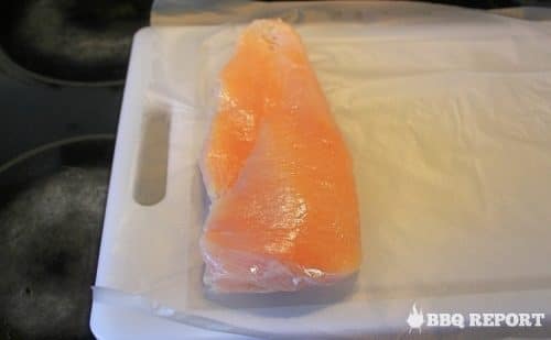 Chicken breast half on plastic wrap