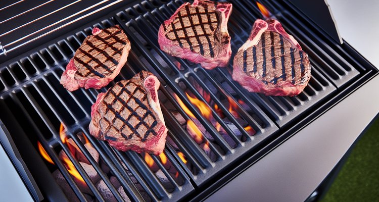 Cast iron grill grates creating perfect sear marks on ribeye steaks