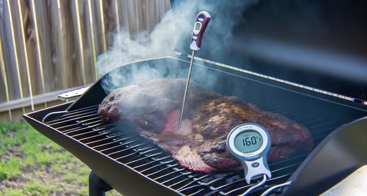 Digital thermometer probes monitoring brisket internal temperature