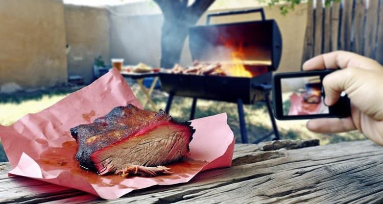 Wrapping brisket in pink butcher paper during Texas Crutch