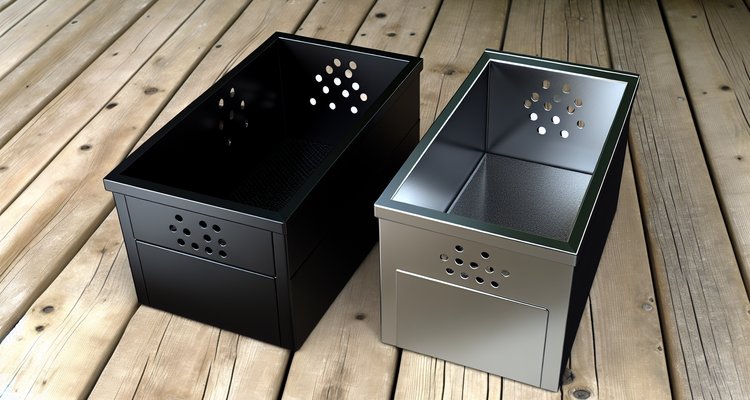 Cast iron smoker box next to stainless steel smoker box side by side comparison on wooden deck