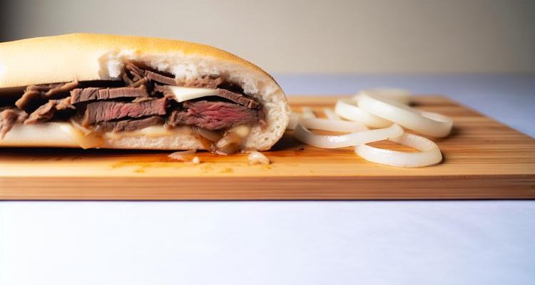 Inside view of Philly cheesesteak showing layers of ribeye, cheese, and onions