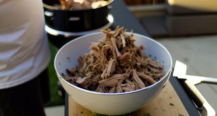 Finished pulled pork shoulder shredded and ready to serve