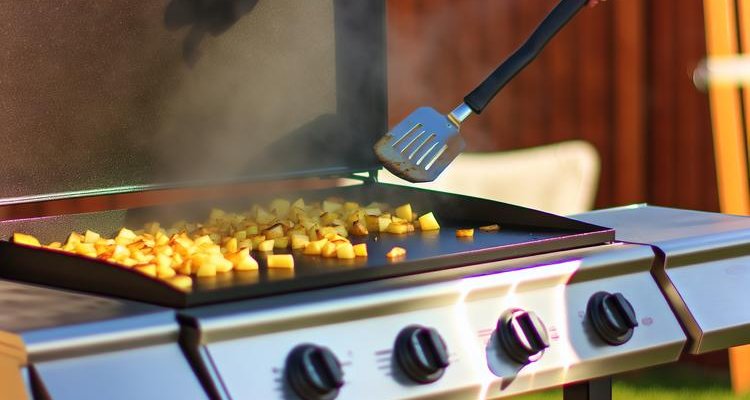 diced russet potatoes developing golden crust on Blackstone griddle with butter melting