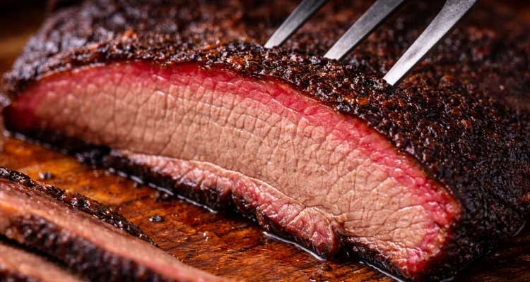 Perfect smoked brisket slice showing smoke ring and juicy texture