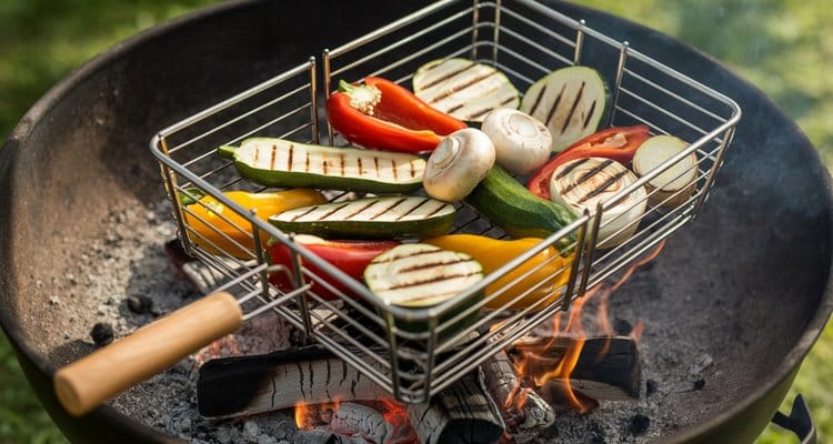Grilling vegetables in a rolling grill basket