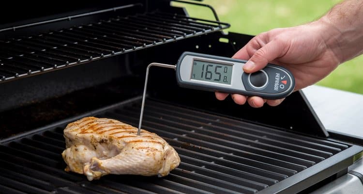 Proper thermometer insertion technique showing probe in thickest part of chicken breast