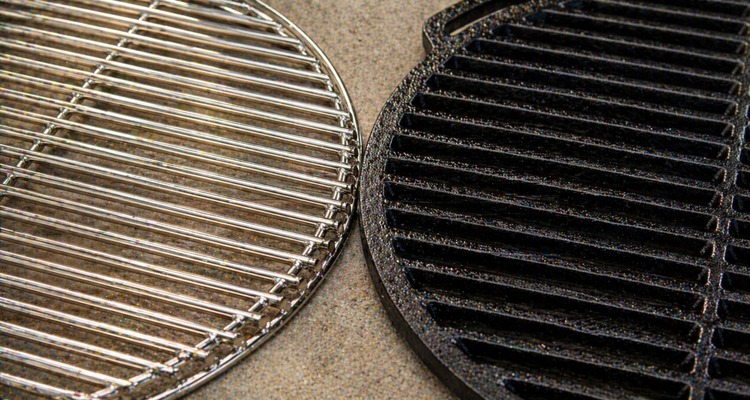 Side-by-side comparison of a shiny stainless steel grill grate and a well-seasoned matte black cast iron grill grate