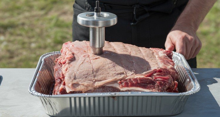 Meat injector inserted into the flat of a trimmed brisket