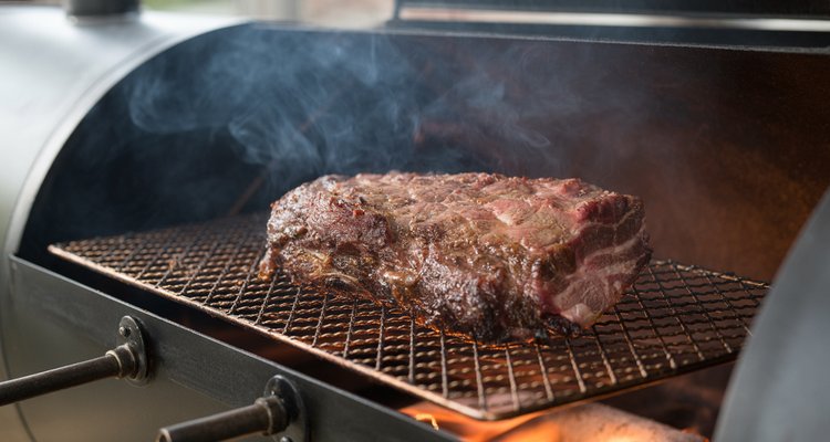 Educational infographic diagram showing a cross-section of brisket on a smoker grate with blue arrows representing evaporative cooling rising from the meat surface and red arrows representing pit heat pressing down, with labels showing the stall equilibrium