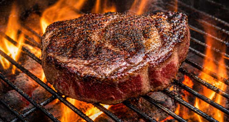 Charcoal grill searing a steak