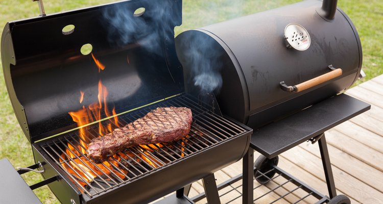 Backyard BBQ scene with tri-tip searing over direct flames on a charcoal grill next to an offset smoker producing thin blue smoke