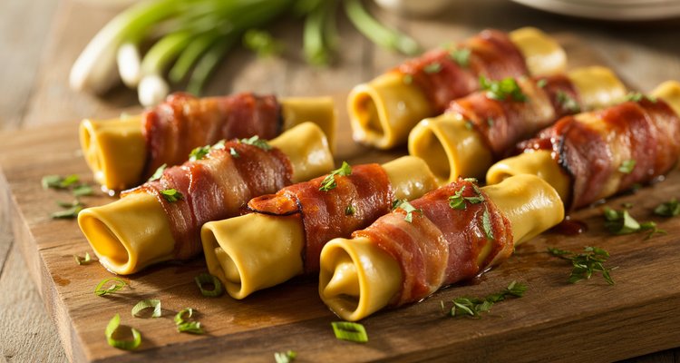Smoked shotgun shells glazed with BBQ sauce Smoked shotgun shells on a wooden cutting board, glazed with BBQ sauce and crispy bacon