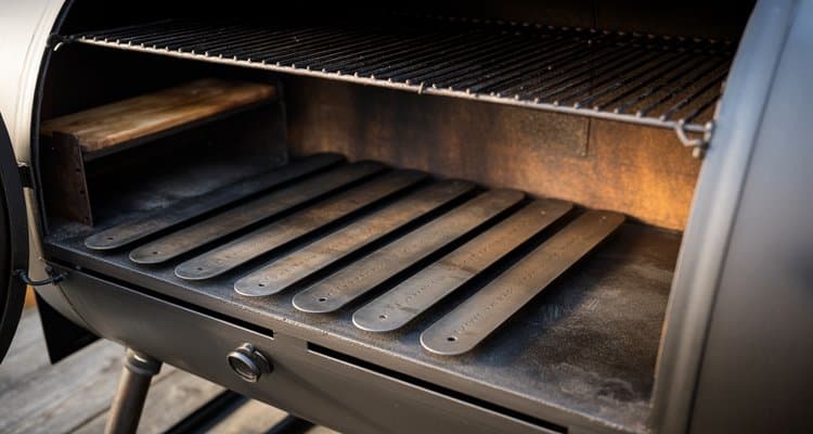 Interior view of offset smoker with steel tuning plates installed below the grates