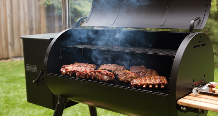 Pellet grill smoking ribs with thin blue smoke for stronger smoke flavor