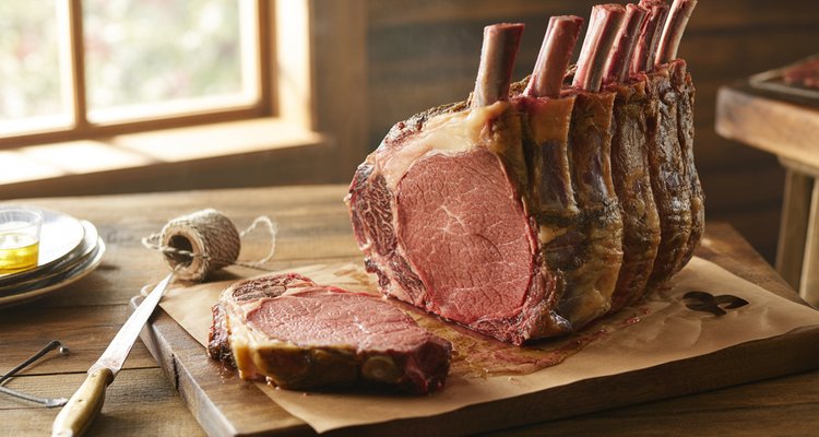 Sliced bone-in prime rib roast on a cutting board for planning how much prime rib per person
