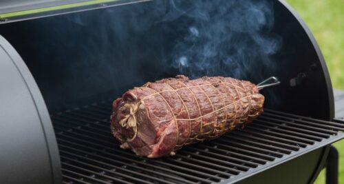 Tied beef tenderloin smoking on pellet grill grates