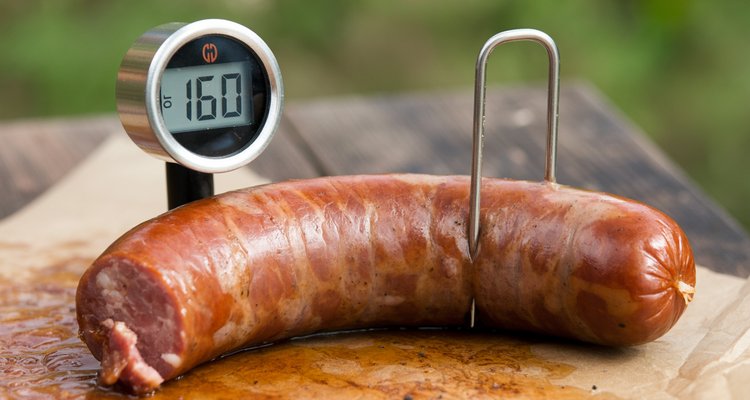 Meat thermometer inserted in a smoked bratwurst reading 160 degrees F