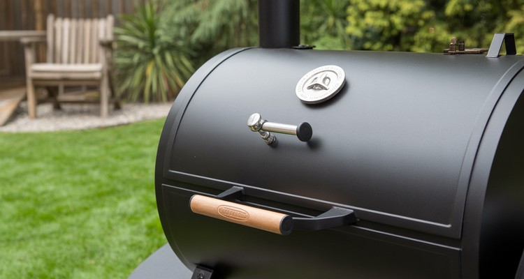 Metal latch installed on a black smoker door for a tighter seal
