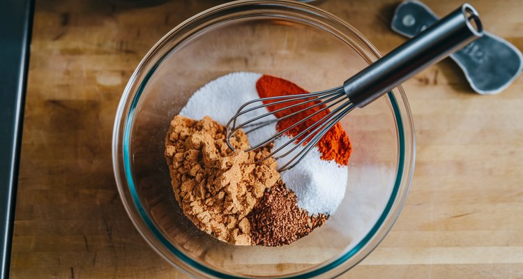 Homemade BBQ rub spices being mixed in a glass bowl