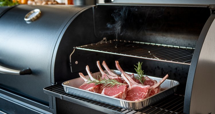 Marinated lamb chops on a tray beside an offset smoker