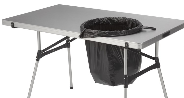 Open metal outdoor trash bag holder frame with black bag stretched over the rim clips beside a grill prep station Open metal outdoor trash bag holder frame with black bag stretched over the rim clips beside a grill prep station