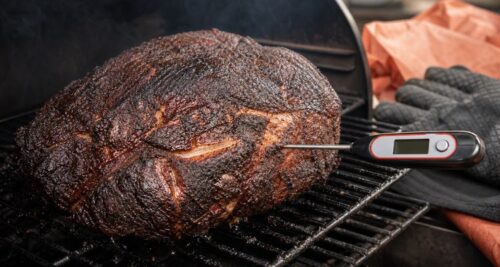 Temperature probe checking a smoked pork shoulder before resting