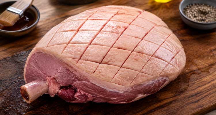 Scoring a bone-in ham fat cap in a diamond pattern before glazing